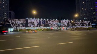 Ночное фото московской улицы с большой световой проекцией: изображения мемов, картины и фото, оживлённые с помощью ИИ.