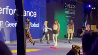 Кадр со сцены конференции по робототехнике и ML: участники и демонстрация на сцене, фон с надписями, часть аудитории видна