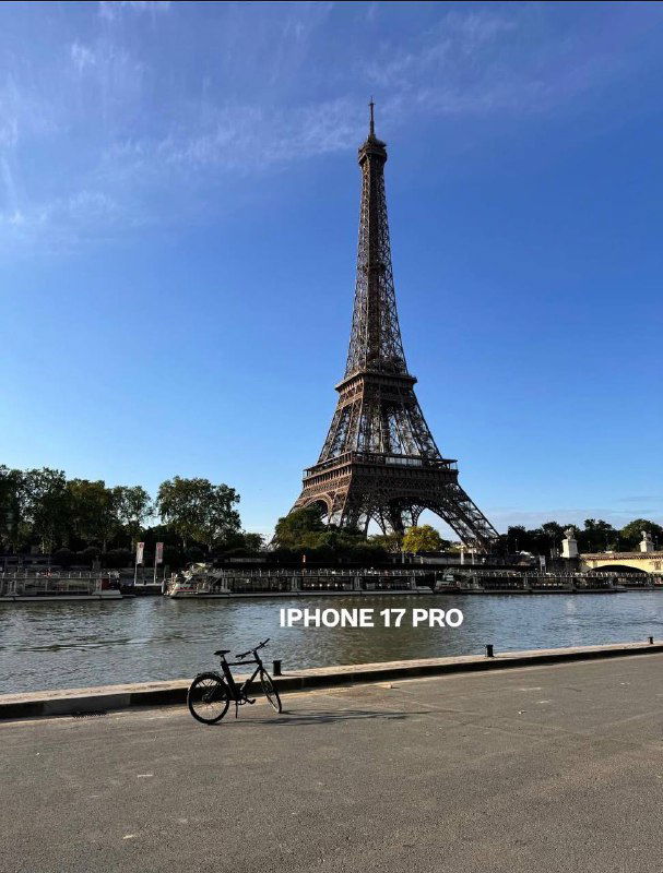 Панорамный снимок Эйфелевой башни и реки Сены, пометка «IPHONE 17 PRO» — пример съёмки на основной модуль нового смартфона в дневном свете.
