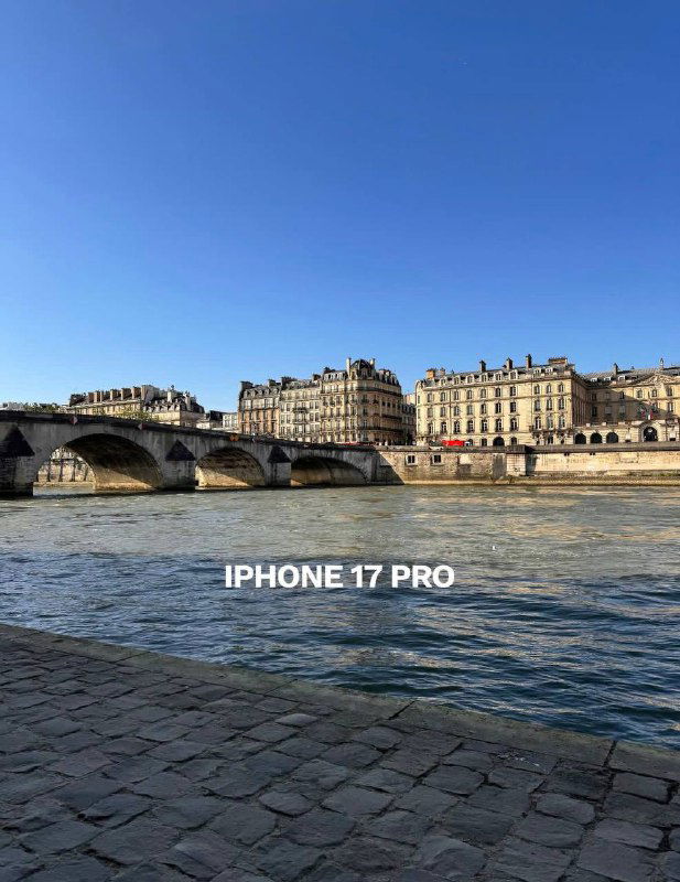 Набережная и набережные камни с видом на реку, подпись «IPHONE 17 PRO» — современный кадр с более точной цветопередачей и детализацией.