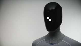Голова гуманоидного робота Figure 03 с чёрным глянцевым лицом и небольшим пиксельным индикатором на ней в студийной обстановке.