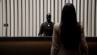 Гуманоид Figure 03 стоит за столом напротив человека, кадр подчёркивает взаимодействие робота с людьми в интерьерной сцене.