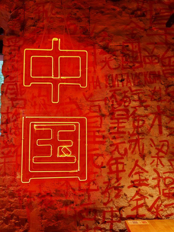 Крупный план неоновой вывески с иероглифом «中国» на красном фоне и текстурами граффити внутри ресторана Чихо.