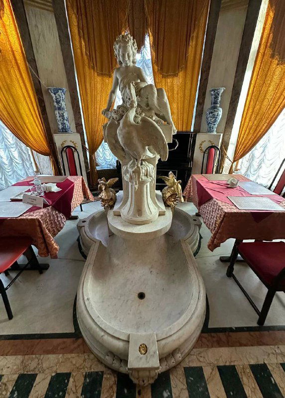 Мраморная статуя и сервированные столики с золотыми занавесами — часть дворцовой атмосферы в столовой на Пречистенке