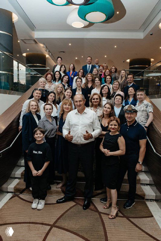 Большая групповая фотография участников конференции по медиации на лестнице отеля: организаторы и гости улыбаются и позируют для совместного кадра.