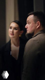 Кадр из видео: мужчина в профиль и женщина на заднем плане в интерьере — иллюстрация поста о блогерском контенте и работе с отелями.