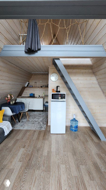 Интерьер небольшого деревянного домика: мини-кухня, обеденная зона и антресоль, светлое дерево, простая мебель — пример уютной дачной планировки у Москвы.