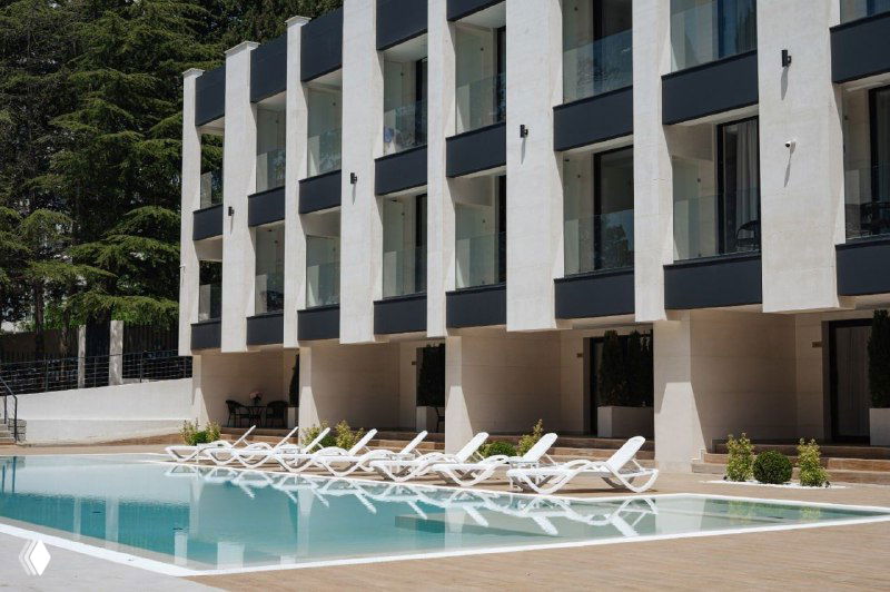 Бассейн и шезлонги у партнерского отеля Monteville в Сочи: вид на зону отдыха и фасад отеля для участников FitMarketers Hub.