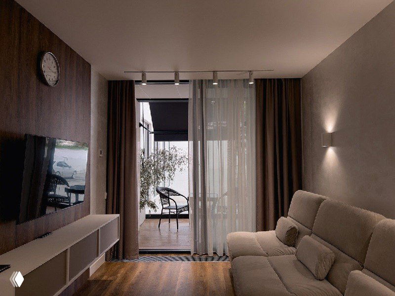 Интерьер номера в партнерском отеле: современная комната с диваном, телевизором и балконом — пример условий проживания для участников хаба.