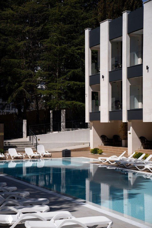 Ещё один ракурс бассейна и шезлонгов у отеля в Сочи: ухоженная территория и место для отдыха участников конференции между сессиями.