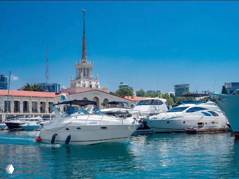 Яхты в сочинской марине на фоне городского пейзажа и причала — иллюстрация запланированной зимней прогулки на скоростных яхтах для участников.