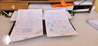 Два протокола встреч на столе: листы с рукописными заметками, цветовые пометки и схемы для маркетинговых сессий и протоколов.