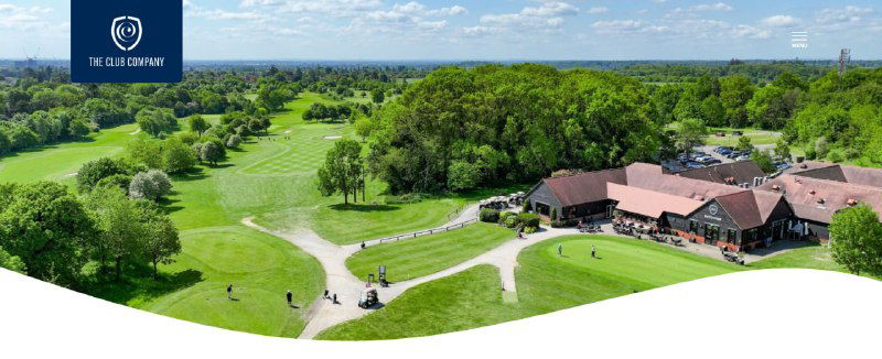 Панорамный снимок гольф-клуба The Club Company: поле, клубный дом, дорожки и лесистые окрестности в Великобритании.