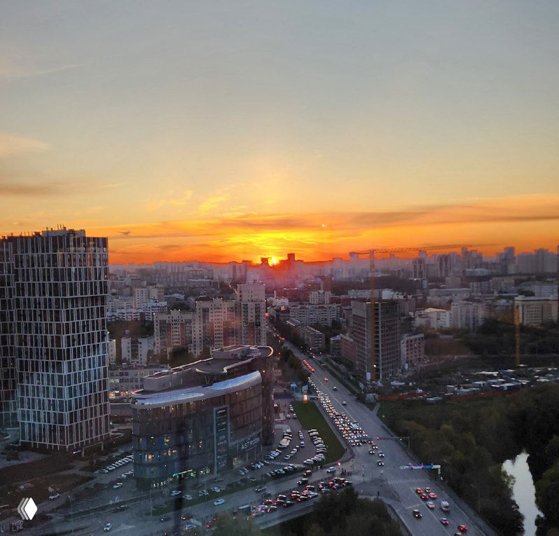 Закат над Екатеринбургом с высоты ресторана Bright Fit; городской силуэт, дороги и вечернее небо, контекст деловой программы и панорамы.
