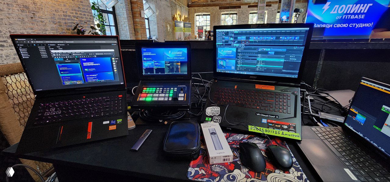 Рабочее место технической команды с ноутбуками, пультом и другой техникой для трансляции и управления презентациями на ивенте Fitbase «Допинг».