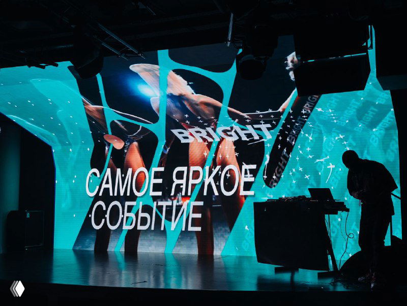 Сцена Bright Conf с крупной световой проекцией «САМОЕ ЯРКОЕ СОБЫТИЕ», яркими LED-экранами, техникой и силуэтами операторов в зале.
