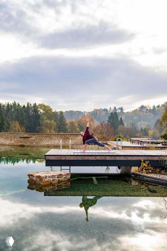 Кадр с практикой йоги на деревянном пирсе над озером, спокойная композиция для образа wellness и гармонии.