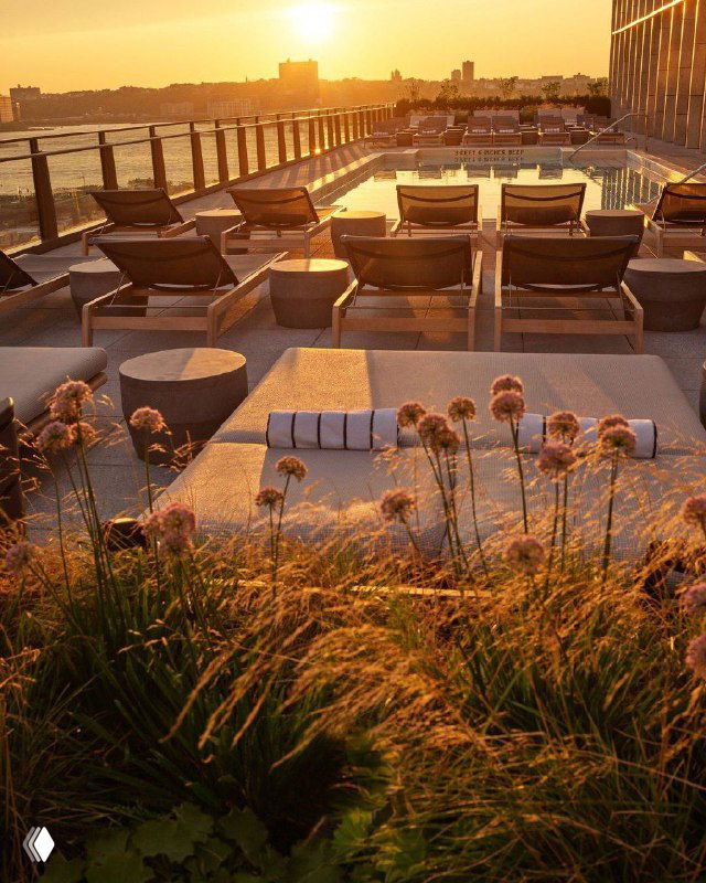 Закат на крыше отеля с шезлонгами и растительностью, тёплый цветовой тон усиливает ощущение уединённого отдыха в городе.