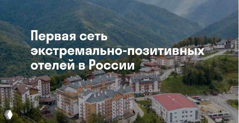 Аэросъёмка горного комплекса отеля сети Ays: несколько корпусов в альпийской долине и надпись «Первая сеть экстремально‑позитивных отелей в России», вид сверху.