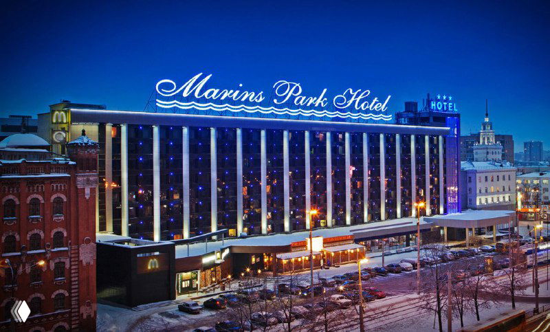 Фасад с подсветкой ночного гостиничного комплекса и вывеской «Marins Park Hotel» — пример одного из партнёров по размещению участников конференции