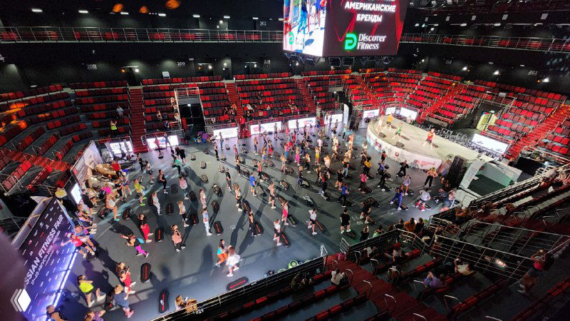 Вид сверху на зал мероприятия в Москве с многочисленными посетителями и стендами, демонстрирующий интенсивный трафик и активности на ивенте.