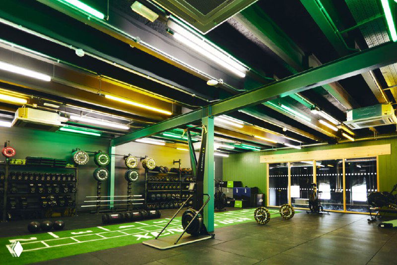 Функциональная зона с зелёными акцентами: зона для кросс-тренинга, штанги, канаты и разметка для групповых функциональных тренировок и циклических программ.
