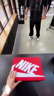 Руки держат коробку с логотипом Nike на фоне магазина — короткий сценарий с узнаваемым объектом, подходящий для развлекательного формата рилса в велнесс‑аккаунте.