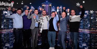 Группа людей позирует в Bullet Time фотозоне на корпоративе на фоне неонового городского бэкдропа; видно развлекательную зону и праздничную атмосферу.