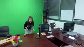 В помещении с зелёным экраном и столом: сотрудник у стола демонстрирует подготовку студии для голографического решения и фотозоны с техникой на столе.