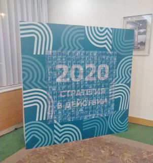 Фотография фотомозаики: бирюзовая панель с крупной надписью «2020», составленной из множества миниатюрных фото.