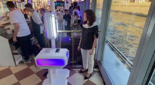 Интерактивная фотостойка «МиксАп» с фиолетовой подсветкой на мероприятии в помещении у окна: видно оборудование, стойку и человека рядом