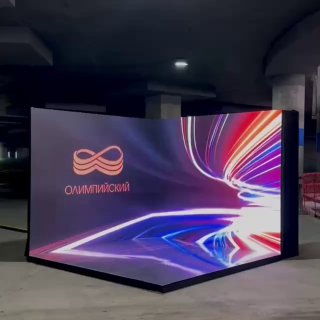 Угловая LED‑фотозона с яркой динамической подсветкой и абстрактной графикой; на экране виден логотип «Олимпийский».