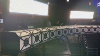 Оборудование Bullet‑Time в тёмном бэкстейдже: изогнутая платформа с мониторами, стойками и яркой подсветкой для объёмной съёмки.