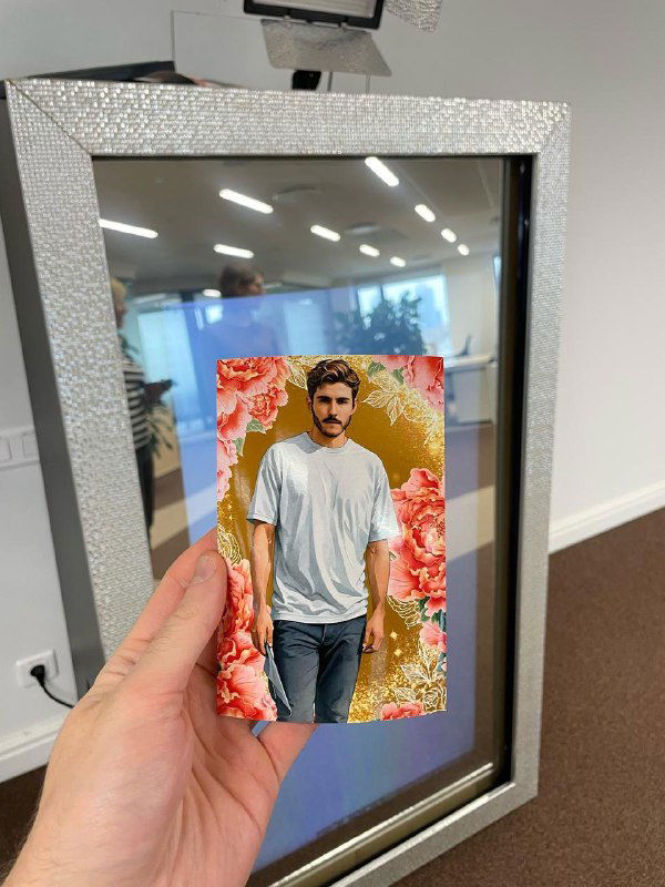 Селфи‑зеркало в блестящей рамке: на экране видно портрет, обработанный нейросетью; устройство держат рукой на фоне офиса.