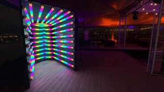 Вид фотозоны «Неоновый Туннель»: вертикальные разноцветные светящиеся трубочки внутри зоны, интенсивная переливающаяся подсветка для эффектных снимков гостей.