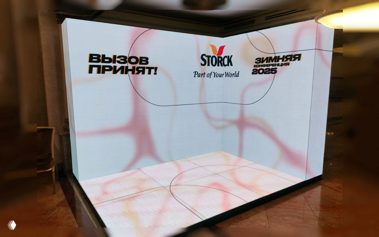 Угловая белая LED‑фотозона с боковыми экранами, световой напольной панелью и логотипом — пример оформления конференции и брендинга.