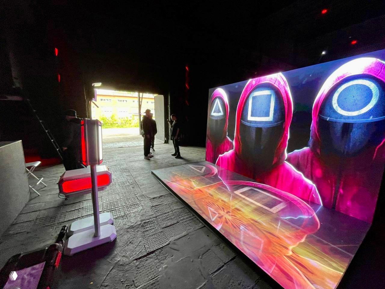 Инсталляция LED‑экрана и фотостойки в затемнённом помещении: большой напольный и задний светодиодный экран с яркой графикой и стойка для съёмки GIF/фото.