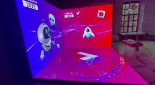 Яркая LED‑фотозона с полом‑экраном и анимированной графикой: насыщенно‑розово‑фиолетовая подсветка, на экране роботы и космические мотивы в зале.