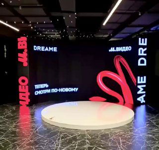 Полукруглый LED-экран с круглой вращающейся платформой Spinner 360, крупными логотипами на экране и эффектной брендированной подсветкой сцены.