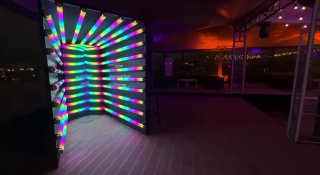 Неоновый туннель — фотозона с яркими полосами RGB‑подсветки, создающая переливающийся цветной фон для съёмок на мероприятии.