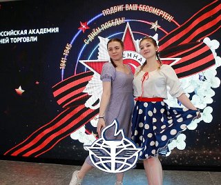 Две девушки в костюмах позируют перед большим светодиодным экраном с праздничной графикой в фотозоне Bullet Time, кадр сделан в интерьере мероприятия