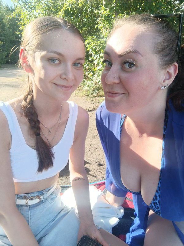 Селфи двух подруг на свежем воздухе в солнечный день: улыбающиеся лица, естественный свет и тёплая дружеская атмосфера на фото.