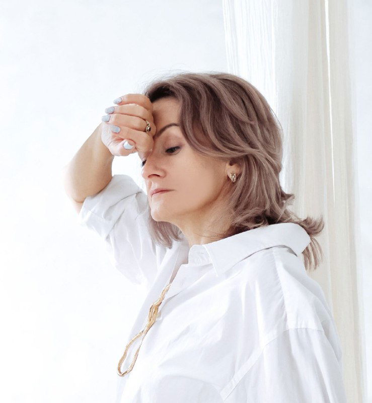 Портрет автора: женщина в белой рубашке, задумчиво опирающаяся рукой о лоб; фото иллюстрирует пост о консультациях и тарифах.