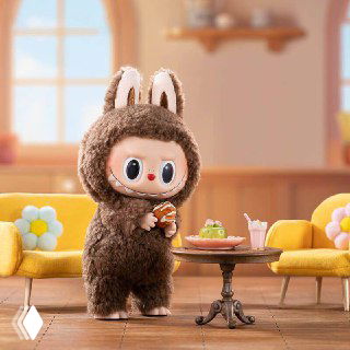 Плюшевый Лабубу на столе в уютной комнате: зубастый милый зверёк в интерьере, иллюстрация феномена ugly-cute и темы поста о тревоге и дофамине.