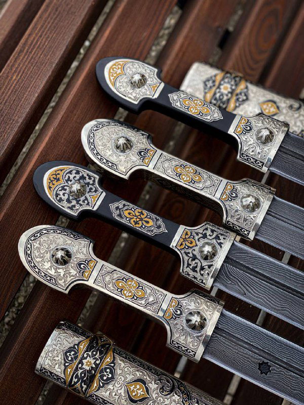 Крупный план наверший ножен и гард: мельхиоровая инкрустация, орнамент и детали сборки, демонстрирующие точную ручную отделку и художественные мотивы.