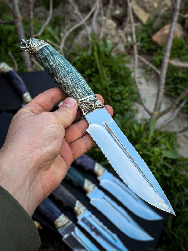 Крупный план рукояти ножа: карельская берёза с декоративными мельхиоровыми деталями, текстура дерева и фурнитуры.