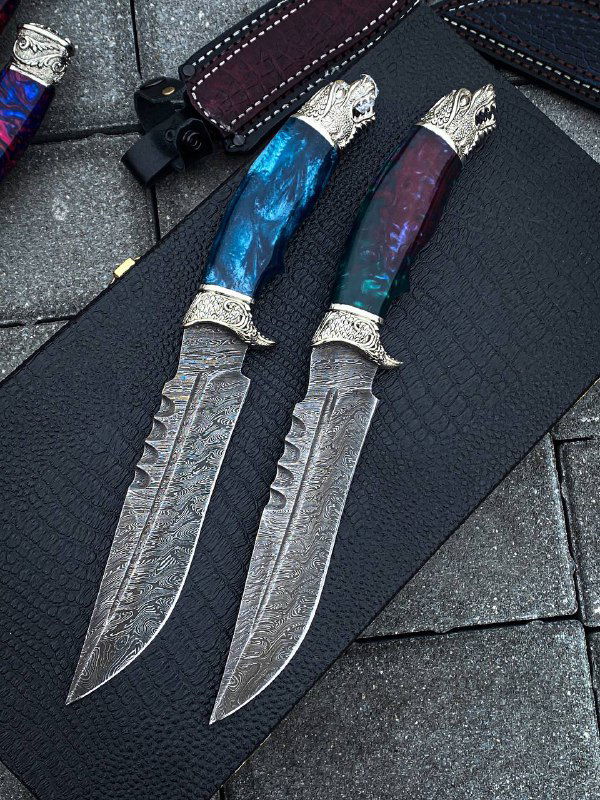 Вид клинков ножей «Дракон» в анфас: выраженный узор дамасковой стали, фигурная заточка и декоративные насечки вдоль обуха.