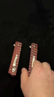 Кадр с рукой рядом с двумя складными ножами танто; видно механизм складывания, текстуру деревянных рукоятей и характерный дамаск на лезвии, демонстрация в руках.