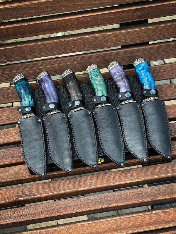 Чёрные кожаные ножны, в которых установлены ножи с рукоятями из стабилизированной карельской берёзы — демонстрация комплектации и посадки в ножнах.
