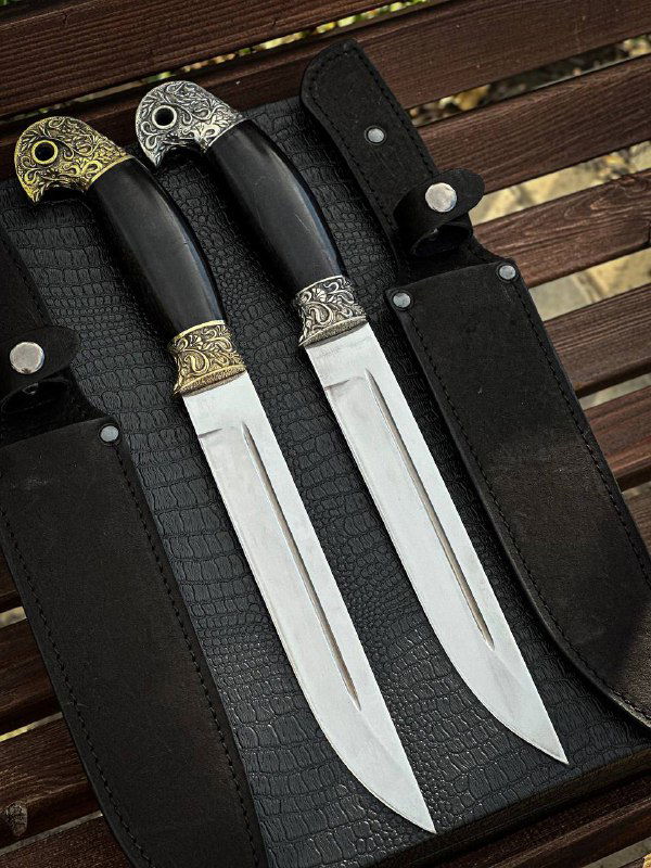 Крупный план двух ножей «Пластунский» в ножнах: видно форму рукояти из граба, отделку гарды и полированные лезвия.